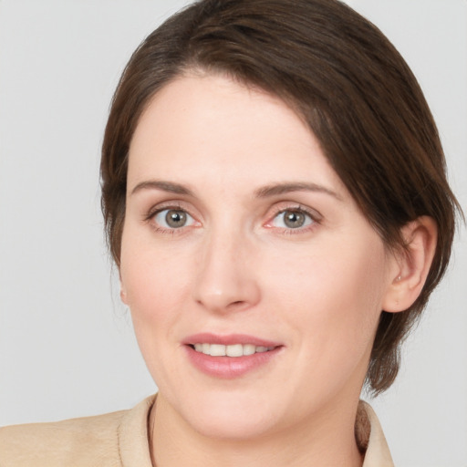 Joyful white young-adult female with medium  brown hair and grey eyes