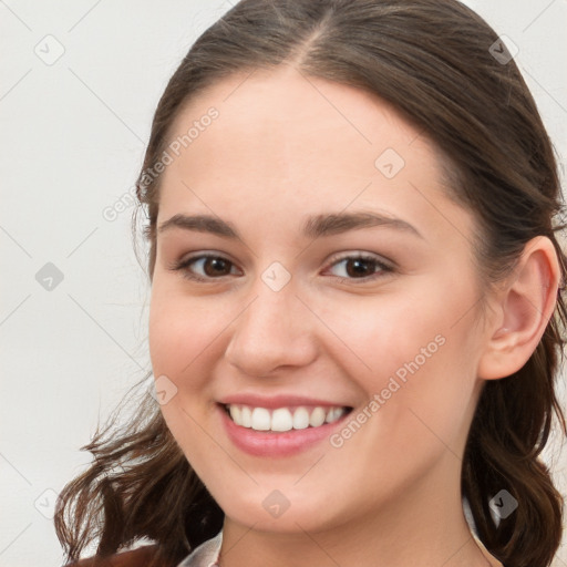 Joyful white young-adult female with long  brown hair and blue eyes