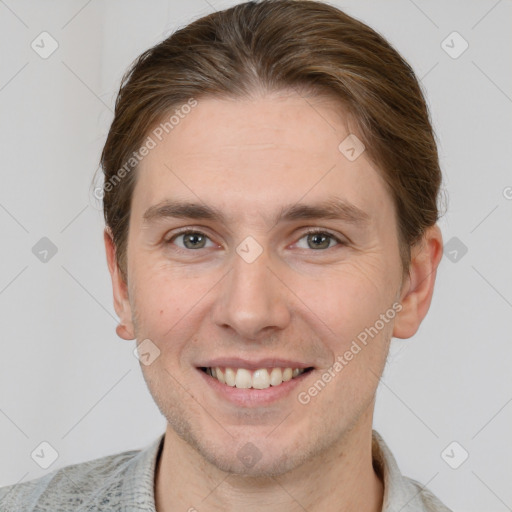 Joyful white young-adult male with short  brown hair and grey eyes