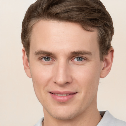 Joyful white young-adult male with short  brown hair and grey eyes