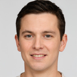 Joyful white young-adult male with short  brown hair and grey eyes