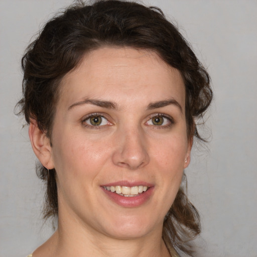 Joyful white young-adult female with medium  brown hair and green eyes