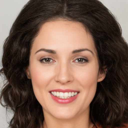 Joyful white young-adult female with long  brown hair and brown eyes