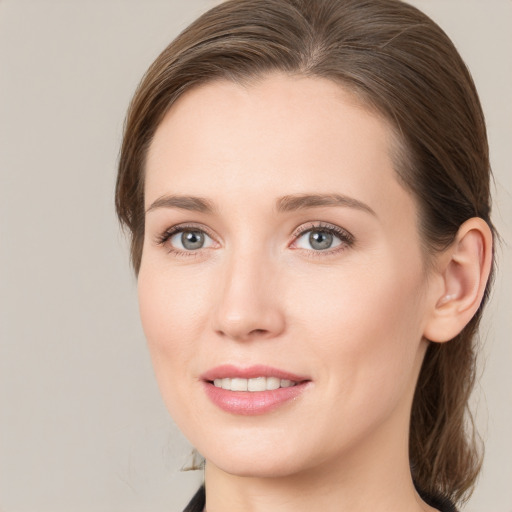 Joyful white young-adult female with medium  brown hair and grey eyes