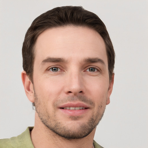 Joyful white young-adult male with short  brown hair and grey eyes