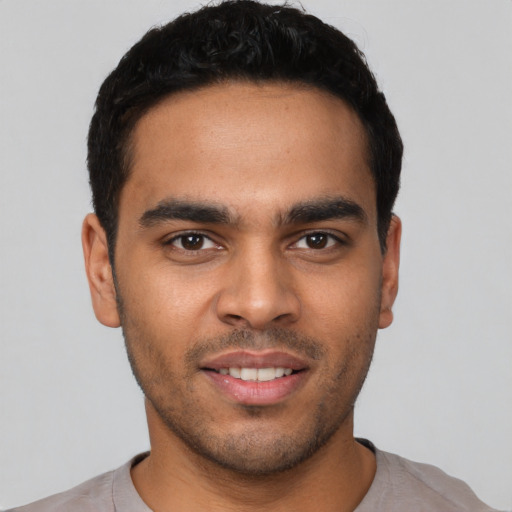 Joyful latino young-adult male with short  black hair and brown eyes
