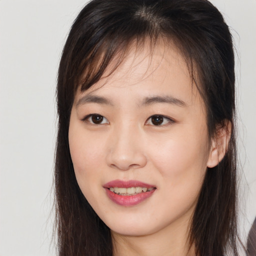 Joyful asian young-adult female with long  brown hair and brown eyes
