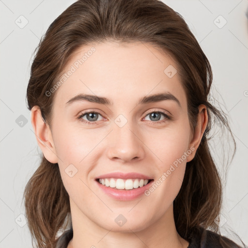 Joyful white young-adult female with medium  brown hair and grey eyes