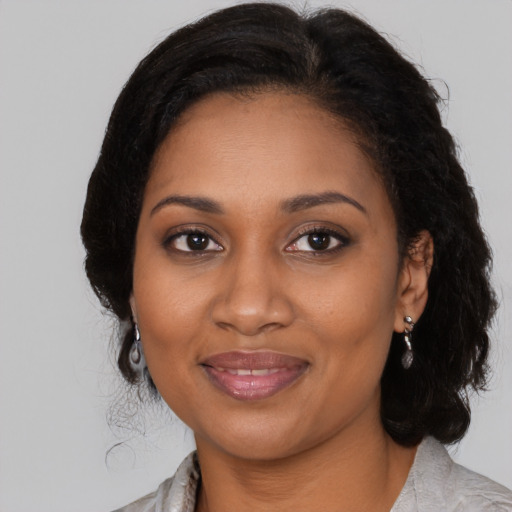 Joyful black young-adult female with medium  brown hair and brown eyes