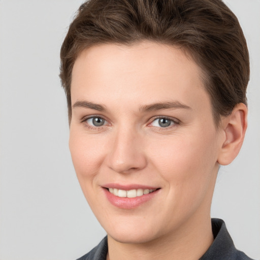 Joyful white young-adult female with short  brown hair and grey eyes