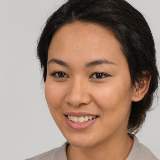 Joyful asian young-adult female with medium  brown hair and brown eyes
