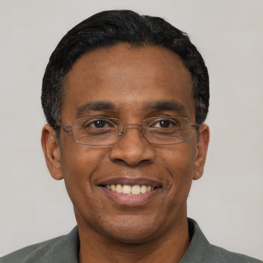 Joyful black adult male with short  black hair and brown eyes