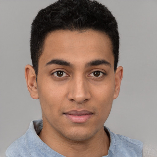 Joyful latino young-adult male with short  black hair and brown eyes