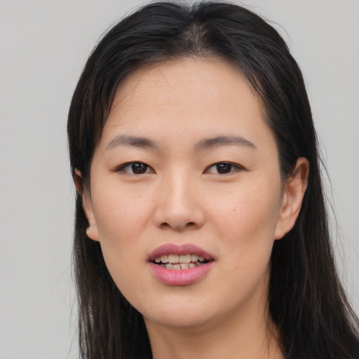 Joyful asian young-adult female with long  brown hair and brown eyes