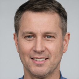 Joyful white adult male with short  brown hair and brown eyes