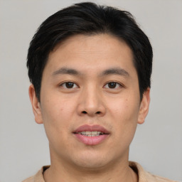 Joyful asian young-adult male with short  brown hair and brown eyes