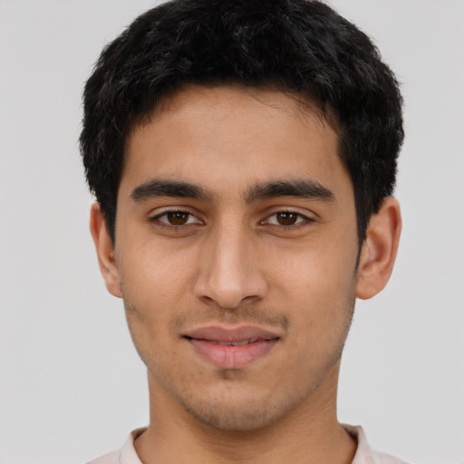 Joyful latino young-adult male with short  black hair and brown eyes