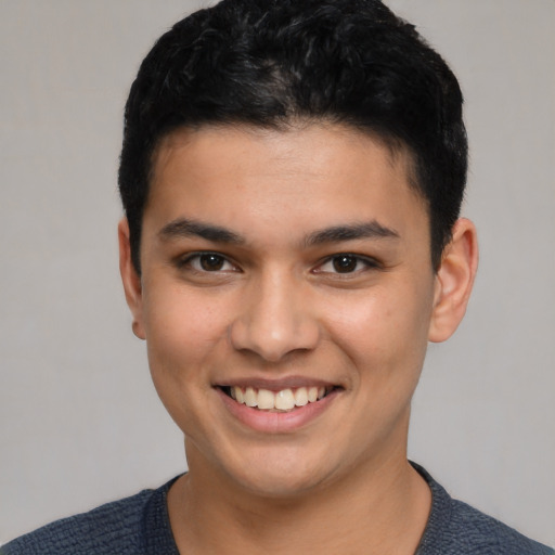 Joyful latino young-adult male with short  black hair and brown eyes