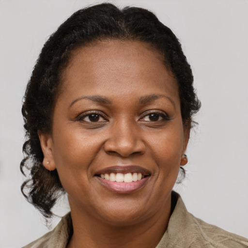 Joyful black adult female with short  brown hair and brown eyes