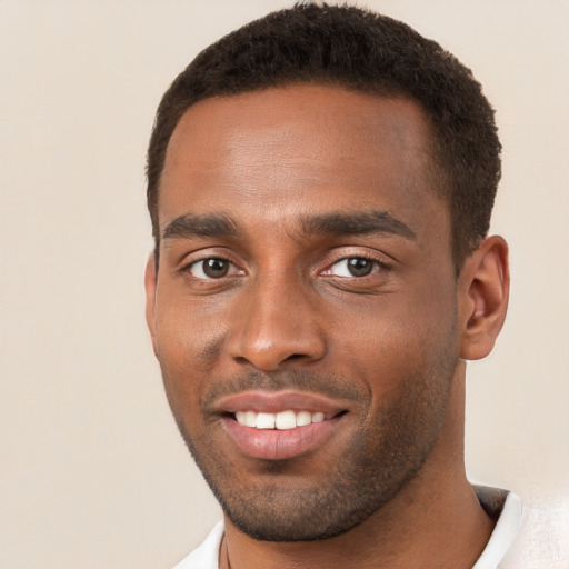 Joyful black young-adult male with short  brown hair and brown eyes