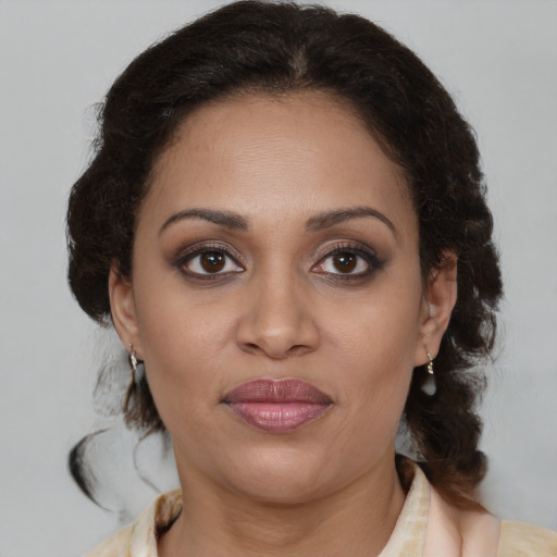 Joyful latino adult female with medium  brown hair and brown eyes