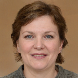 Joyful white adult female with medium  brown hair and grey eyes