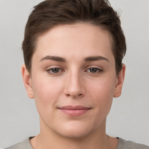 Joyful white young-adult female with short  brown hair and grey eyes