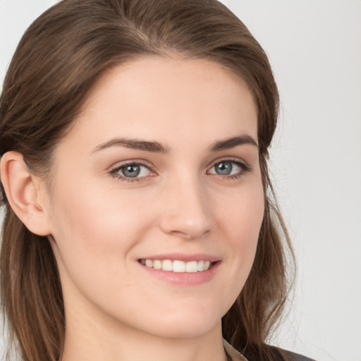 Joyful white young-adult female with long  brown hair and blue eyes