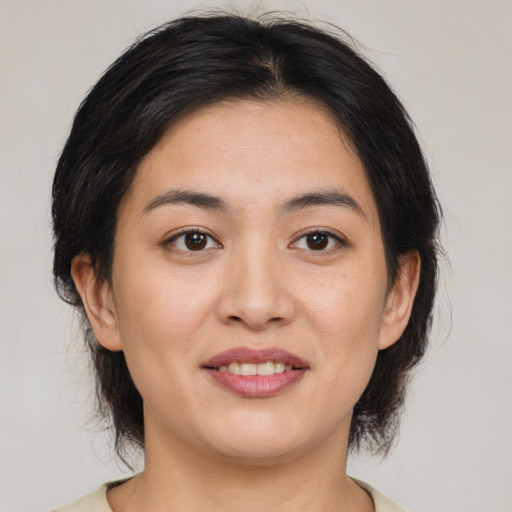 Joyful asian young-adult female with medium  brown hair and brown eyes
