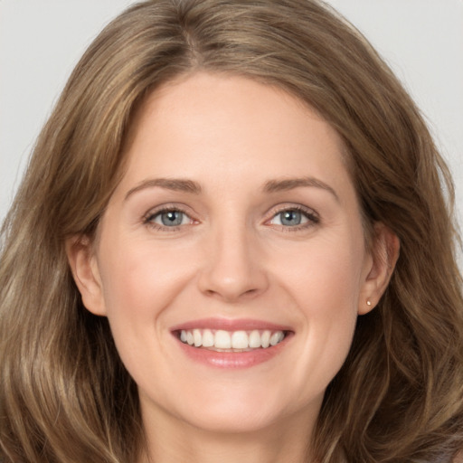 Joyful white young-adult female with long  brown hair and grey eyes