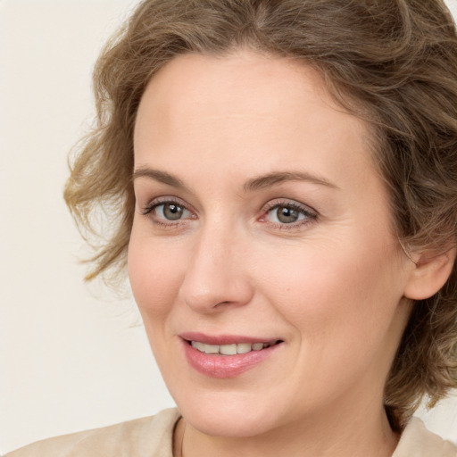 Joyful white young-adult female with medium  brown hair and green eyes