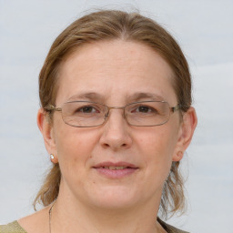 Joyful white adult female with medium  brown hair and blue eyes