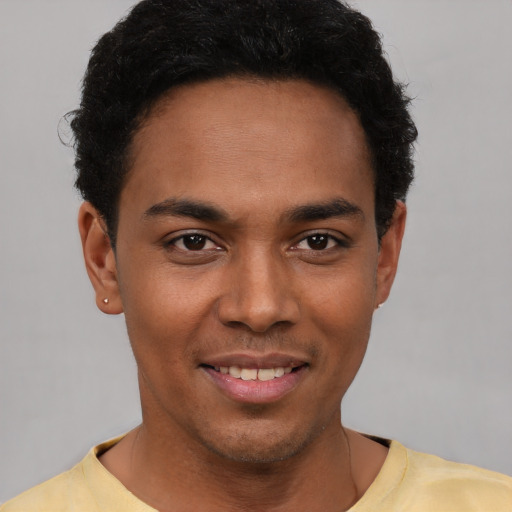 Joyful black young-adult male with short  black hair and brown eyes