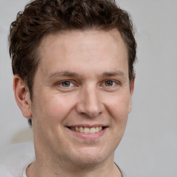 Joyful white adult male with short  brown hair and grey eyes