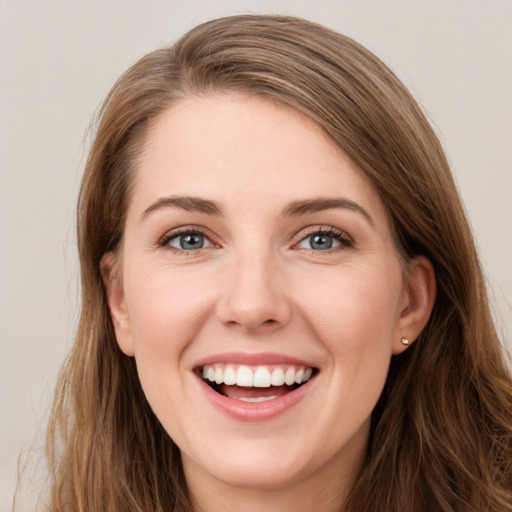 Joyful white young-adult female with long  brown hair and grey eyes