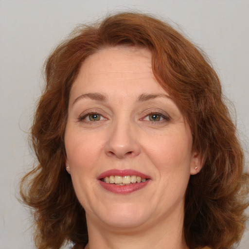 Joyful white adult female with medium  brown hair and green eyes