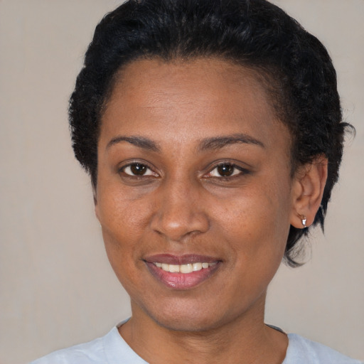 Joyful black young-adult female with short  black hair and brown eyes