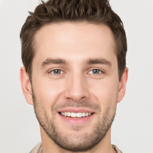 Joyful white young-adult male with short  brown hair and grey eyes