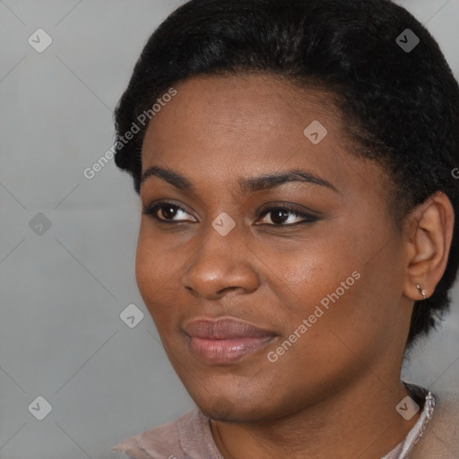 Joyful black young-adult female with short  black hair and brown eyes