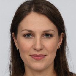 Joyful white adult female with long  brown hair and grey eyes