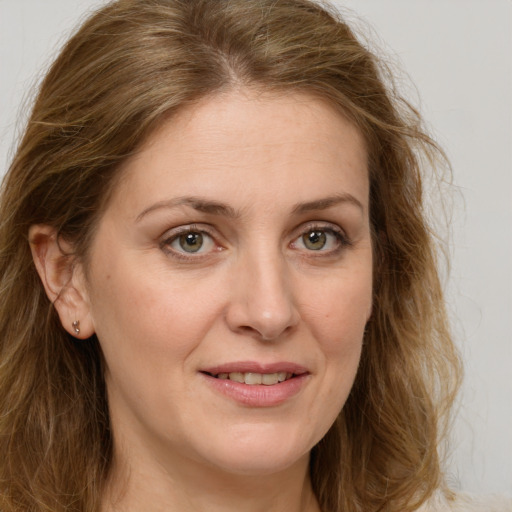 Joyful white adult female with long  brown hair and green eyes