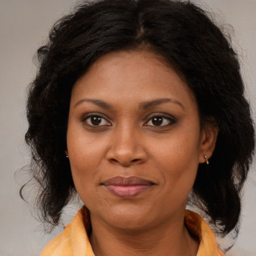 Joyful black adult female with medium  brown hair and brown eyes