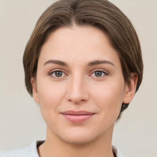 Joyful white young-adult female with short  brown hair and grey eyes