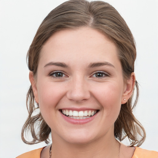 Joyful white young-adult female with medium  brown hair and grey eyes