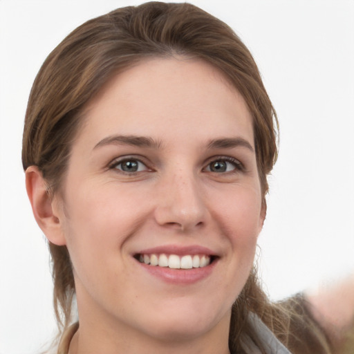 Joyful white young-adult female with medium  brown hair and grey eyes