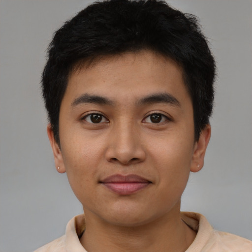 Joyful latino young-adult male with short  black hair and brown eyes