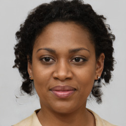 Joyful black adult female with medium  brown hair and brown eyes