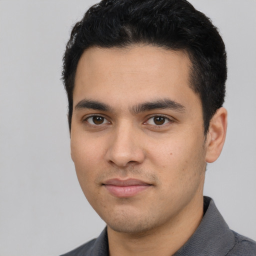 Joyful latino young-adult male with short  black hair and brown eyes