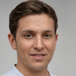 Joyful white young-adult male with short  brown hair and grey eyes