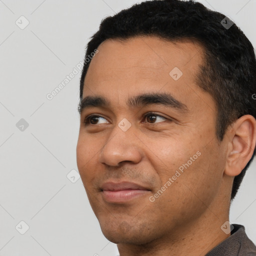 Joyful latino young-adult male with short  black hair and brown eyes